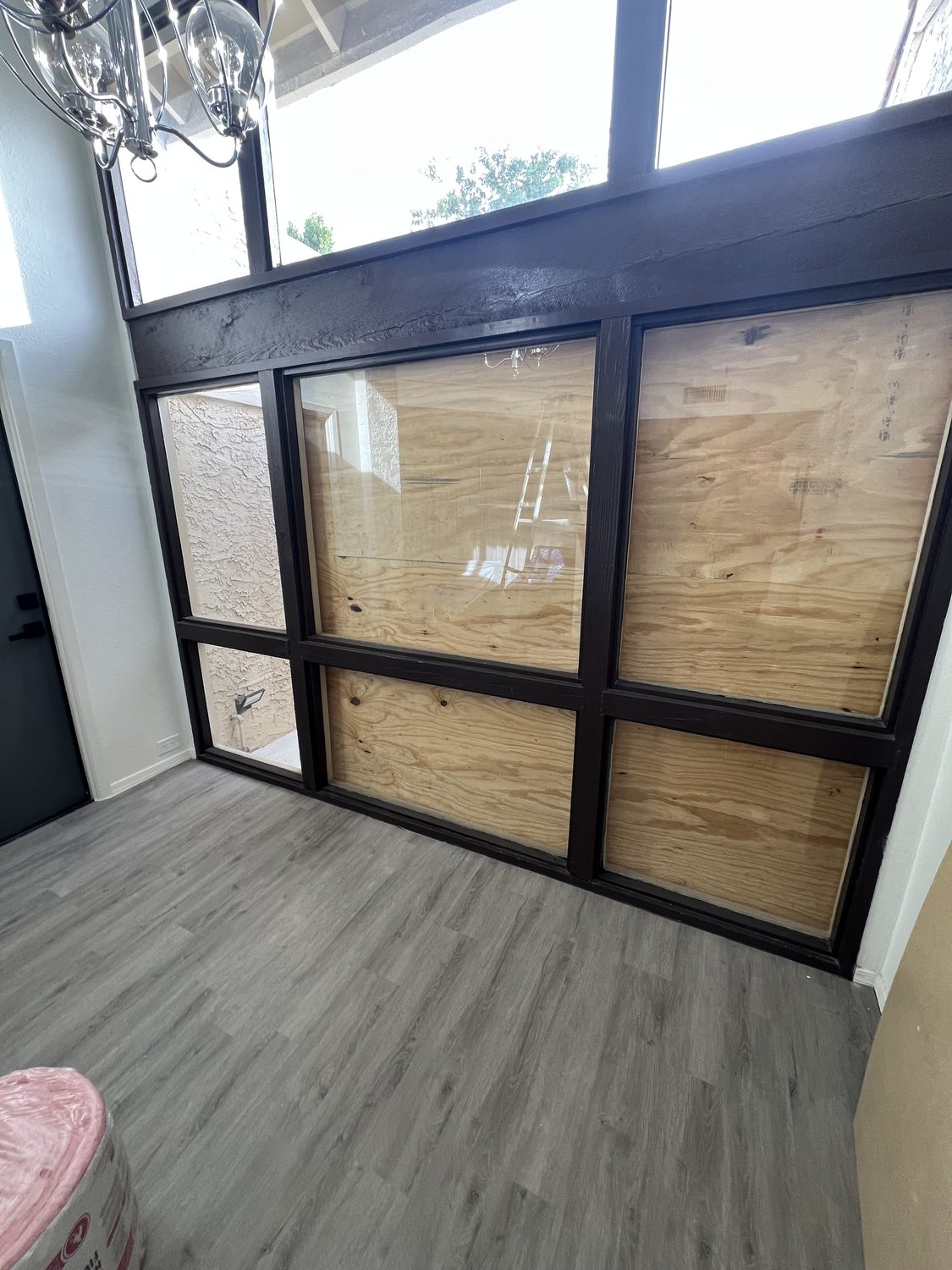 Original interior glass partition wall with a dark grid frame before the accent wall was built