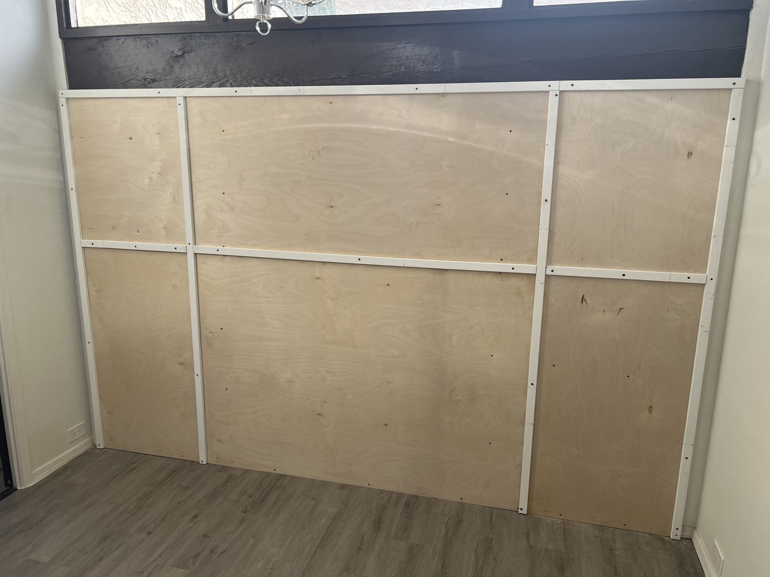 Plywood panels installed over the old partition with white battens laid out in a grid