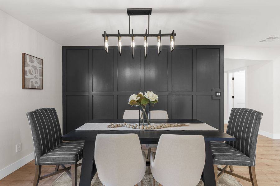 Dining area with a dark accent wall and modern linear light fixture