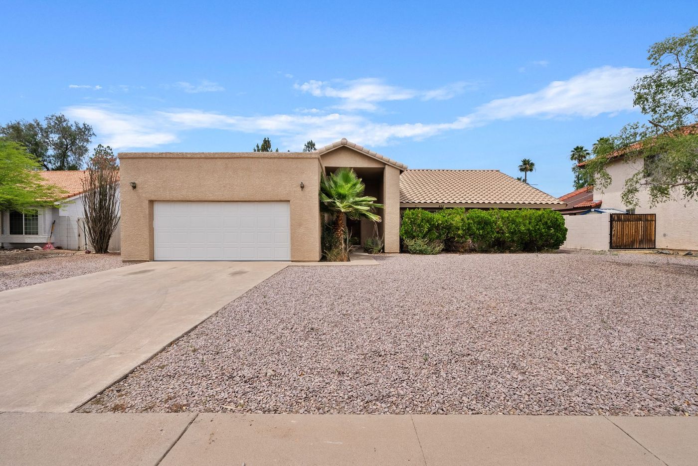 Dated stucco home in Mesa with gravel front yard and plain facade before renovation