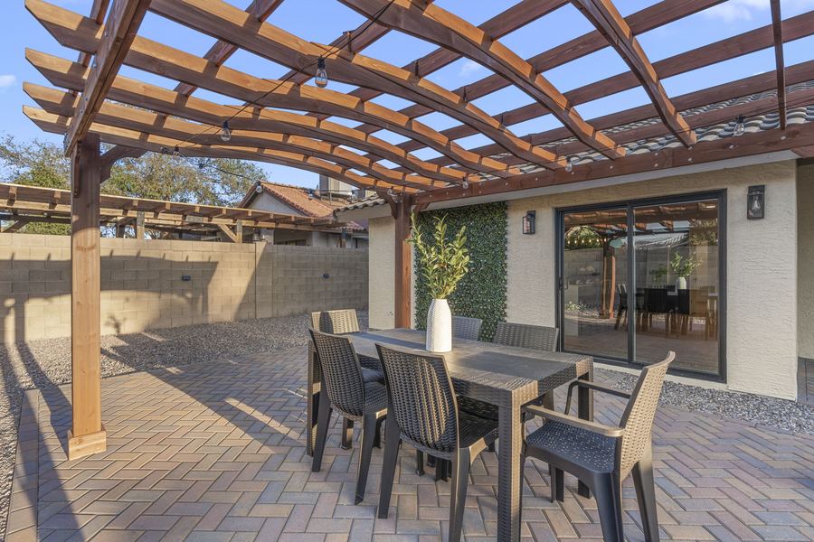 Backyard shade pergola with paver patio and dining seating
