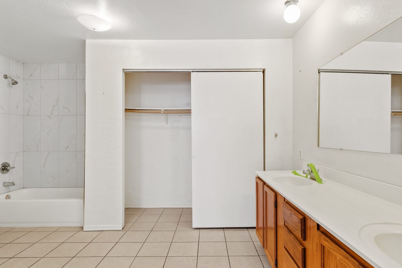 Primary bathroom with oak vanity and cultured marble before renovation