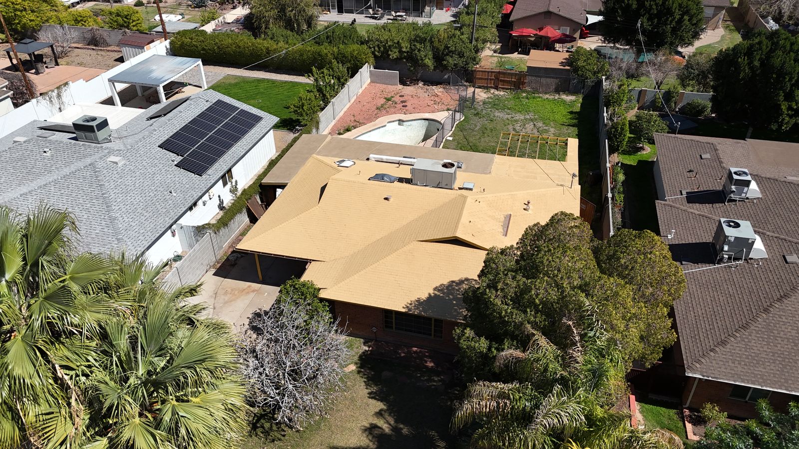 Aerial view of the original single story brick ranch home with its existing pool before demolition
