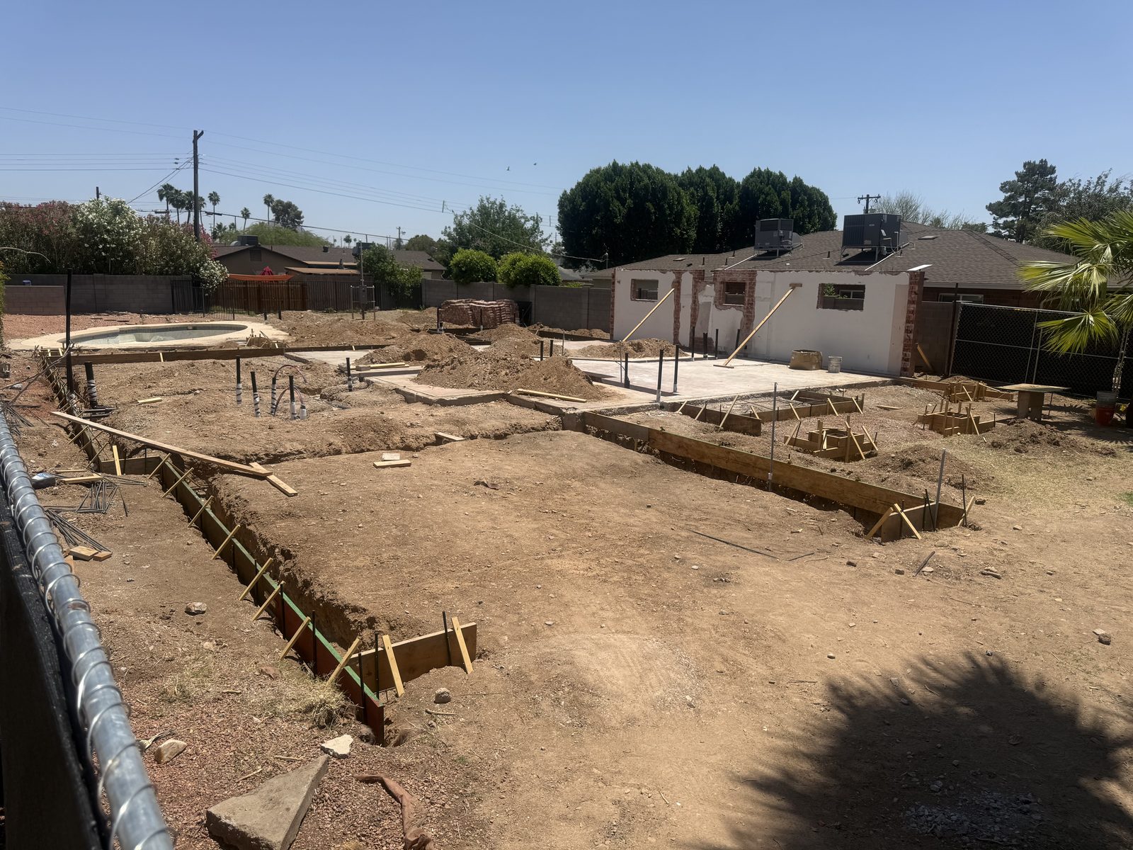 Footing trenches formed and reinforced with rebar next to the retained original brick shell