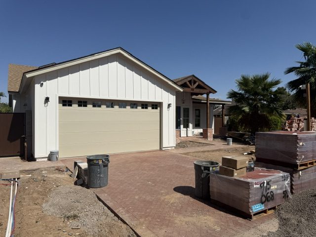 Completed garage elevation with board and batten siding and a new carriage style door