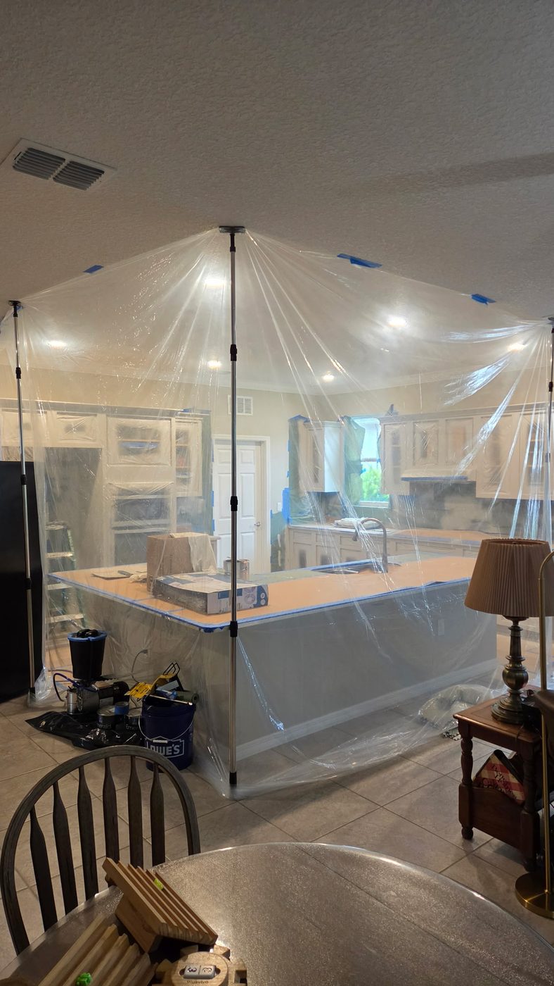 Full plastic containment built with floor to ceiling poles enclosing the kitchen before spraying