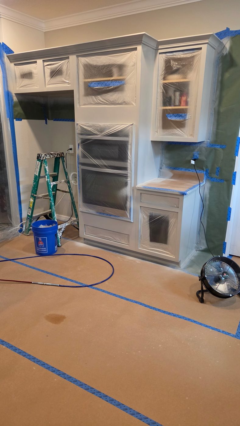 The same cabinets sprayed in a clean white finish with masking still in place