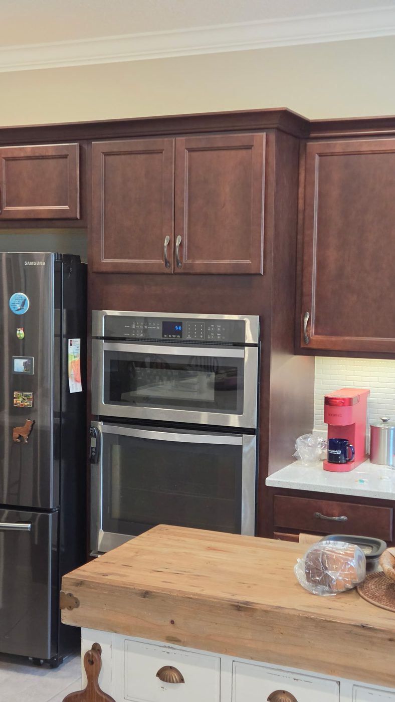 Window wall with dark cherry cabinets and white subway backsplash before refinishing
