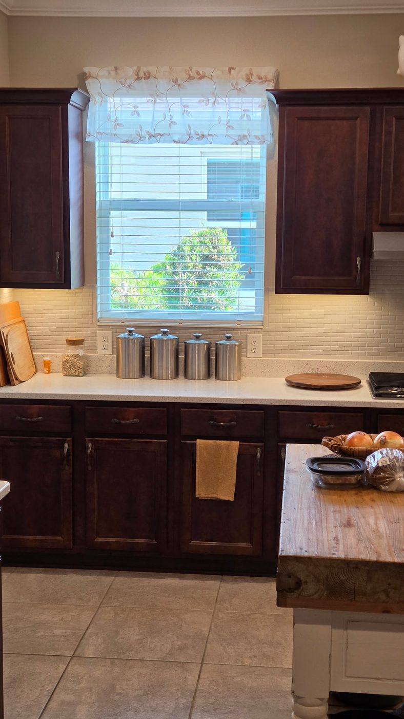 Close view of the dark stained upper cabinets and wall oven before refinishing
