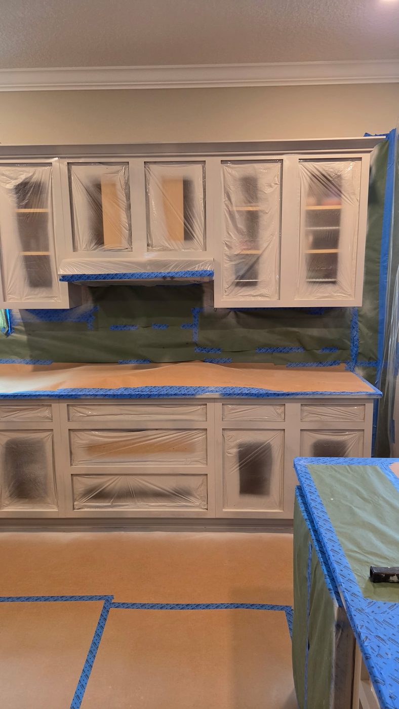 Window wall cabinets sprayed white with masking still in place